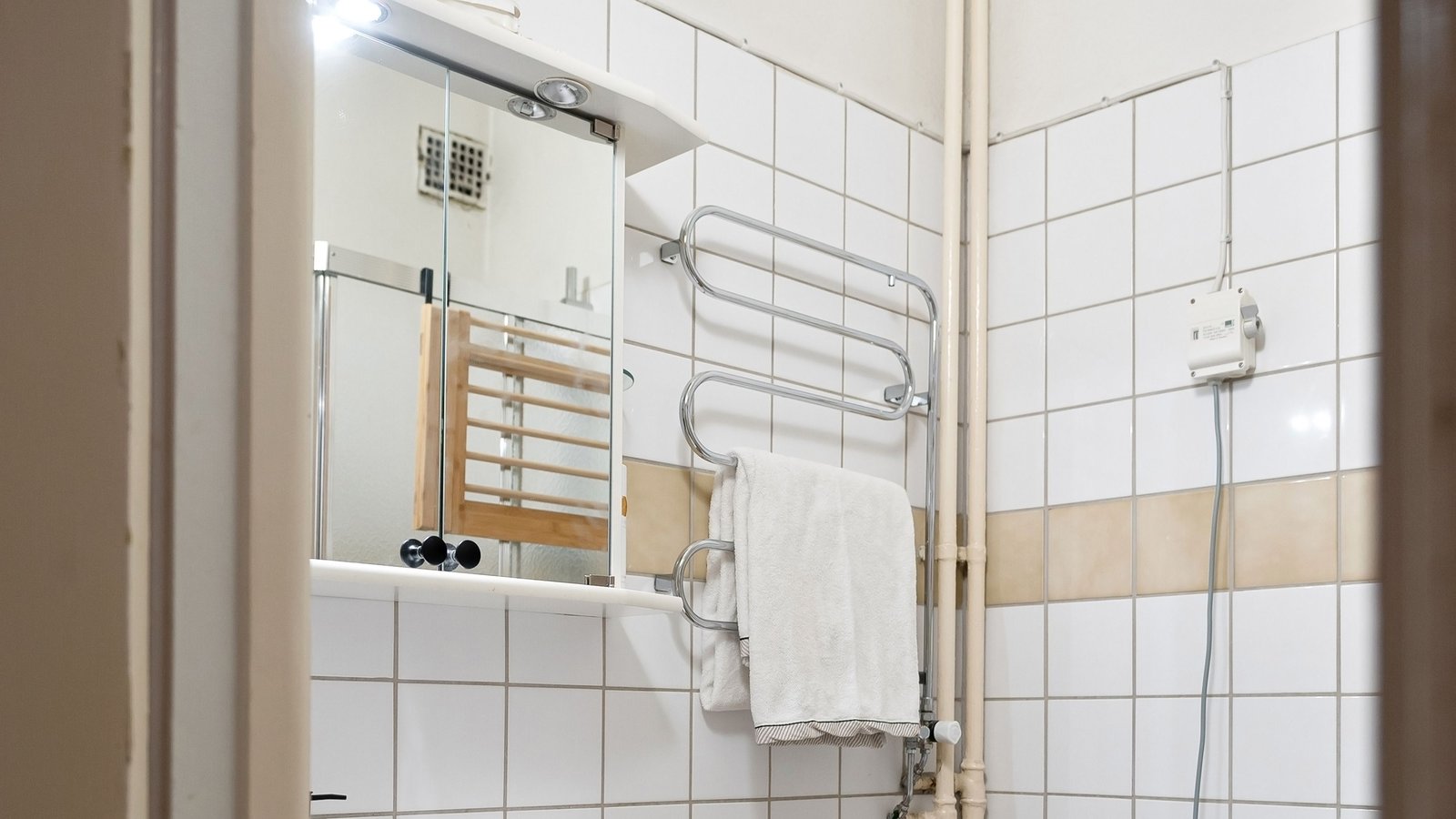 Compact apartment bathroom with shelving — atmosphere, not a product pick