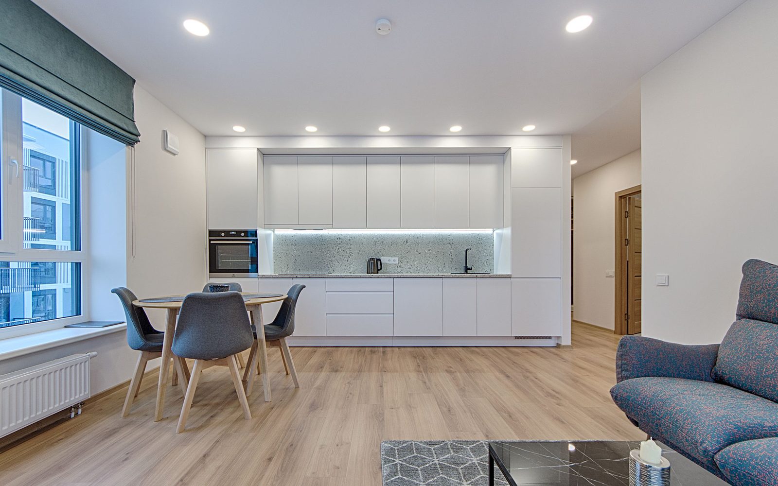 Small round kitchen table with gray chairs beside a white kitchen wall, atmosphere photo, not a VEVOR or IVAR listing photo