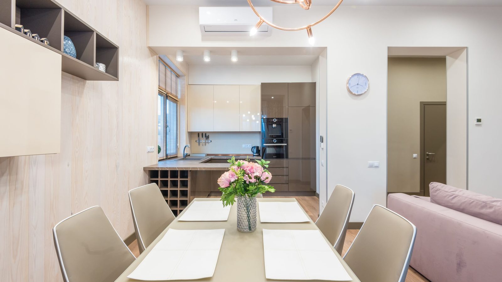 Studio apartment with a compact kitchen and dining zone along one wall, atmosphere photo, not a product pick